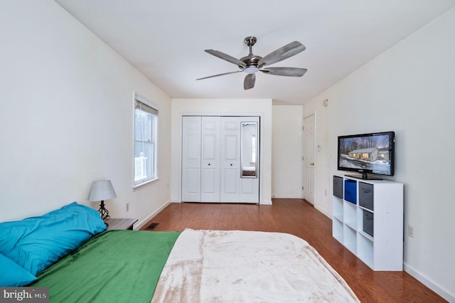 bedroom featuring dark wood-type flooring, ceiling fan, and a closet