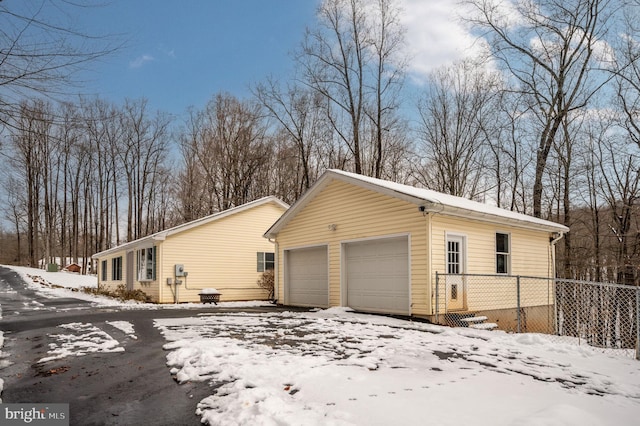 snow covered property with a garage