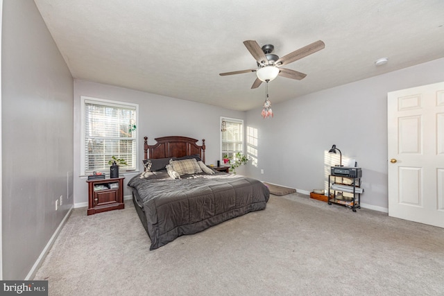 carpeted bedroom with multiple windows, a textured ceiling, and ceiling fan