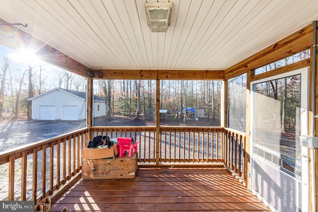 wooden deck featuring a garage and an outdoor structure