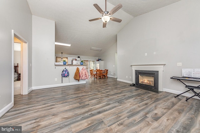 unfurnished living room with hardwood / wood-style flooring, ceiling fan, and lofted ceiling