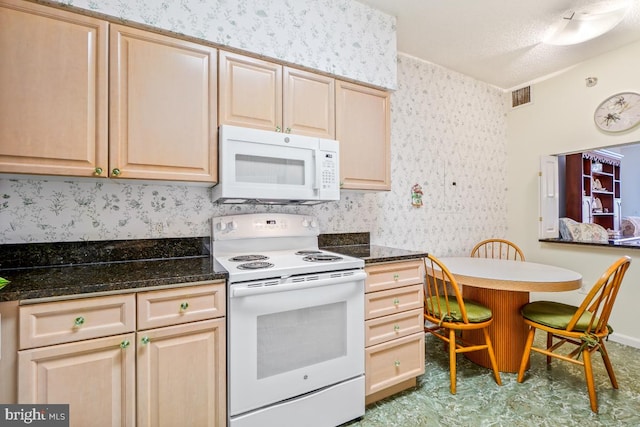 kitchen featuring light brown cabinetry and white appliances