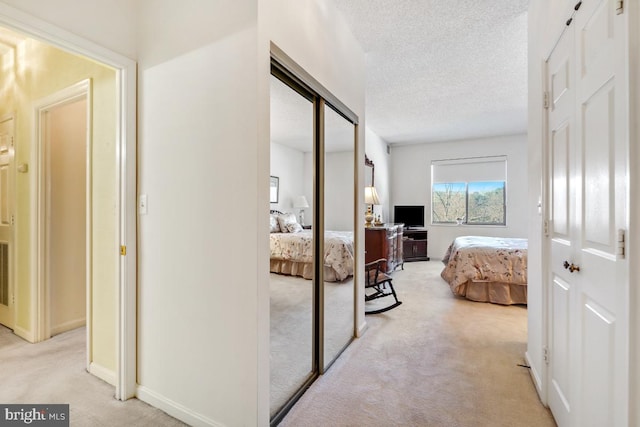 carpeted bedroom with a textured ceiling and a closet