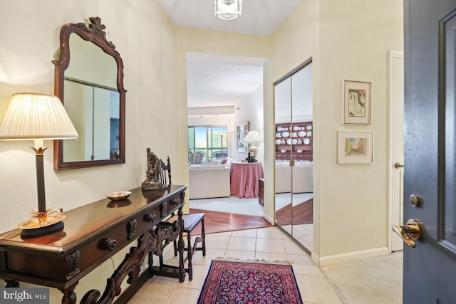 hall with a textured ceiling and light tile patterned floors