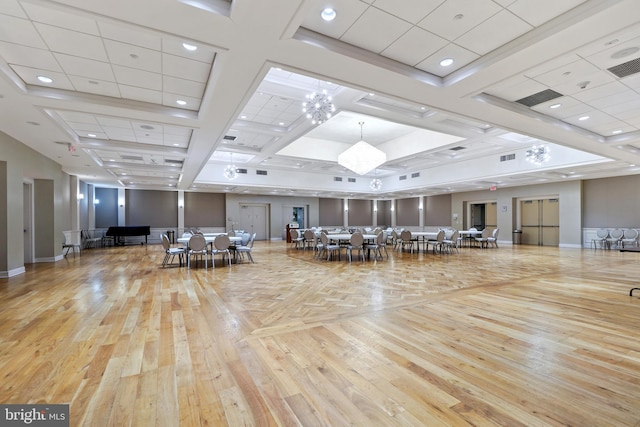 miscellaneous room with an inviting chandelier, light hardwood / wood-style flooring, and a drop ceiling