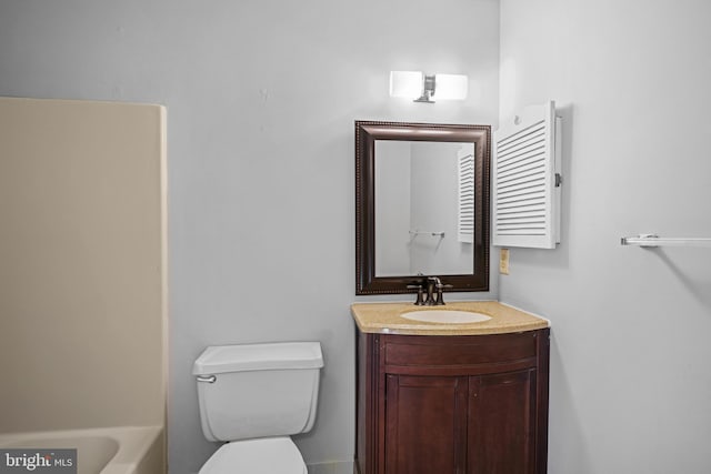 bathroom featuring a tub to relax in, vanity, and toilet