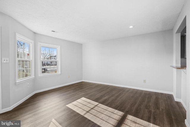 spare room with dark hardwood / wood-style flooring and a textured ceiling