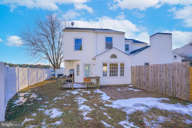 view of snow covered rear of property