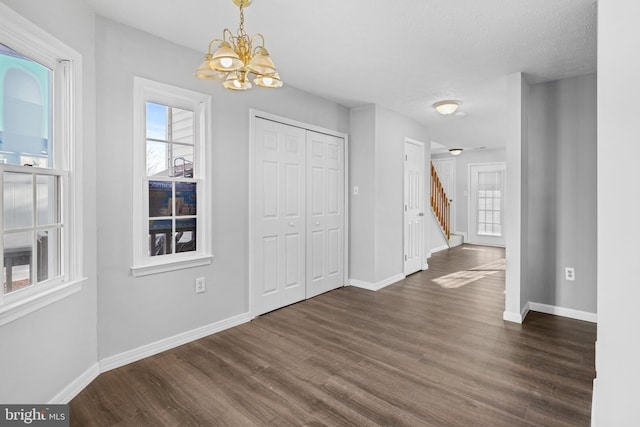 interior space with an inviting chandelier, dark wood-type flooring, and a textured ceiling