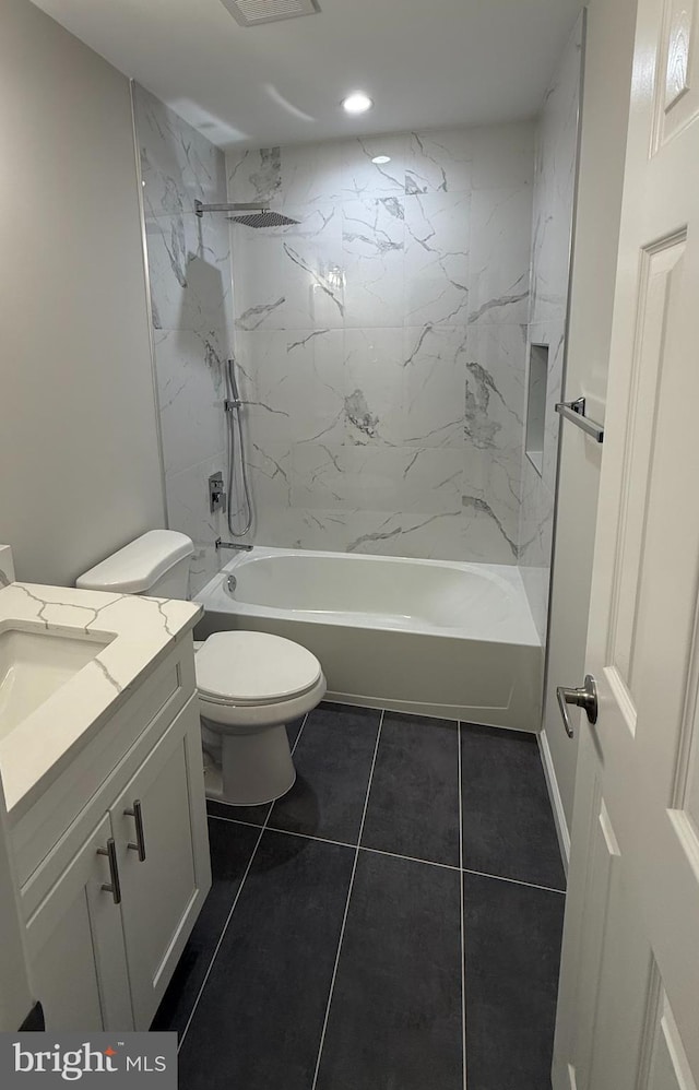 full bathroom featuring tile patterned floors, toilet, vanity, and tiled shower / bath combo