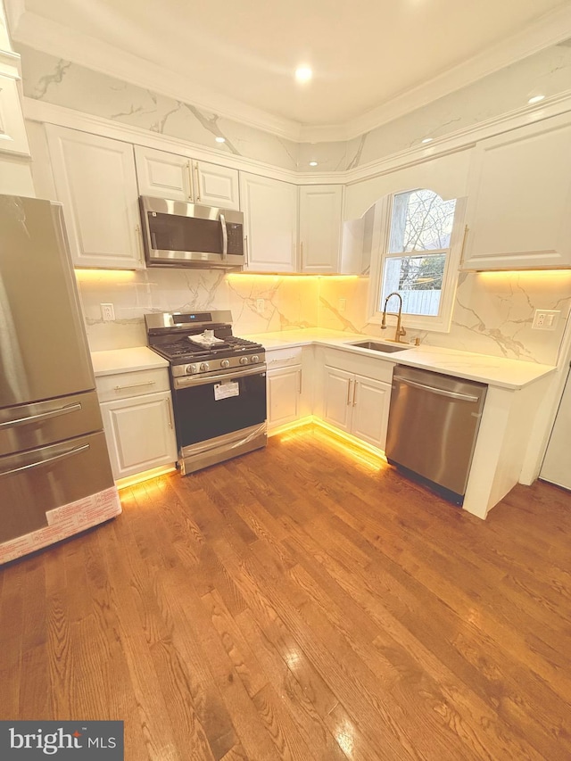 kitchen featuring appliances with stainless steel finishes, white cabinets, and sink