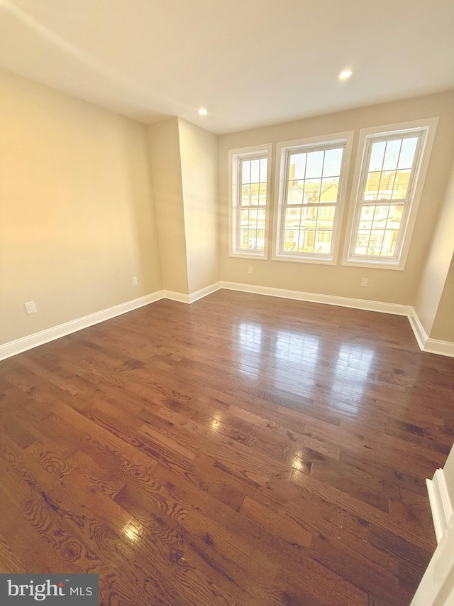 empty room with dark hardwood / wood-style flooring