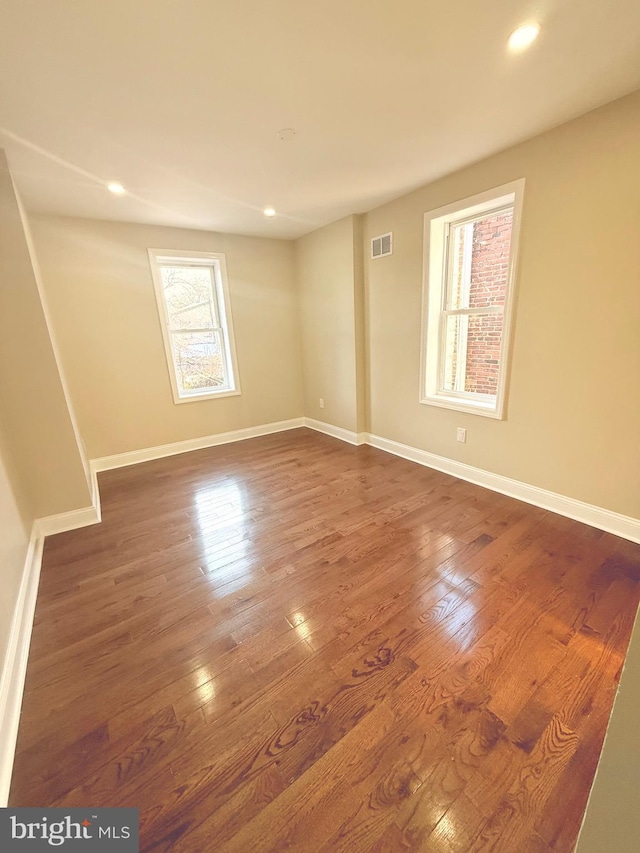 empty room with dark hardwood / wood-style flooring