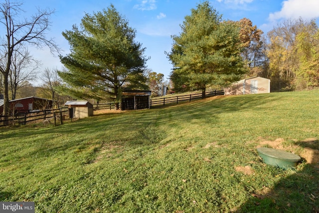 view of yard featuring a rural view and a storage shed