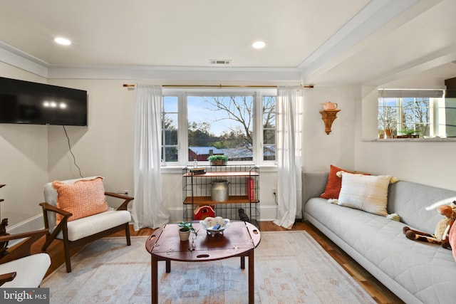 living room with hardwood / wood-style flooring and ornamental molding