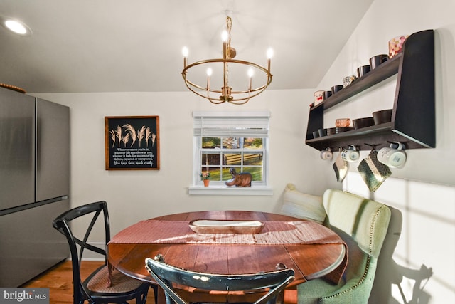 dining space featuring wood-type flooring and a notable chandelier