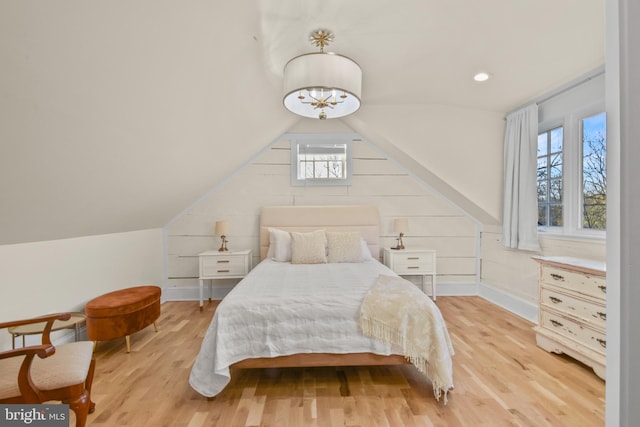 bedroom featuring multiple windows, vaulted ceiling, and light hardwood / wood-style floors