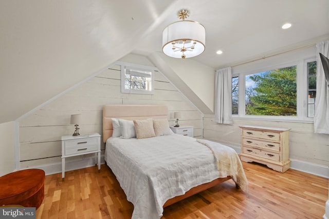 bedroom with lofted ceiling, multiple windows, and light hardwood / wood-style flooring