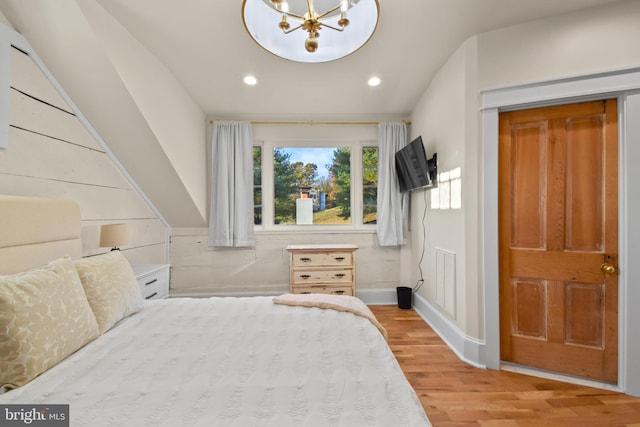 bedroom featuring hardwood / wood-style floors and a chandelier