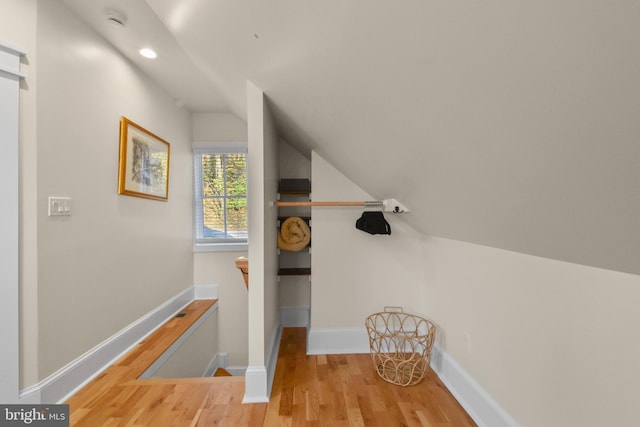 staircase with lofted ceiling and wood-type flooring