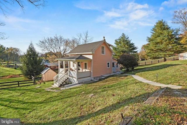 view of property exterior featuring a shed, covered porch, and a lawn