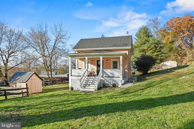 view of outdoor structure with a porch and a lawn