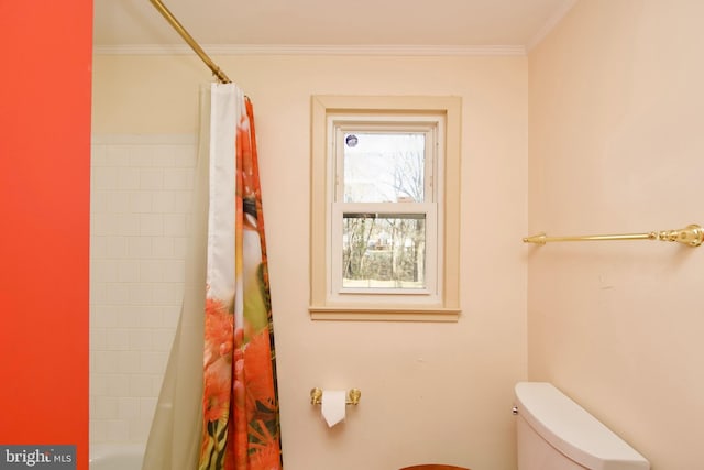 bathroom with ornamental molding, toilet, and shower / bath combo with shower curtain