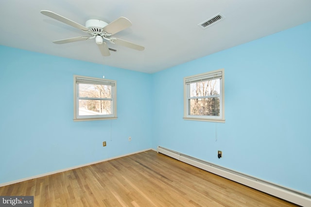 spare room with ceiling fan, a baseboard radiator, light hardwood / wood-style flooring, and a wealth of natural light