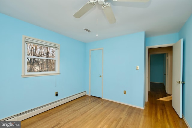 unfurnished bedroom with ceiling fan, a baseboard radiator, and light hardwood / wood-style flooring