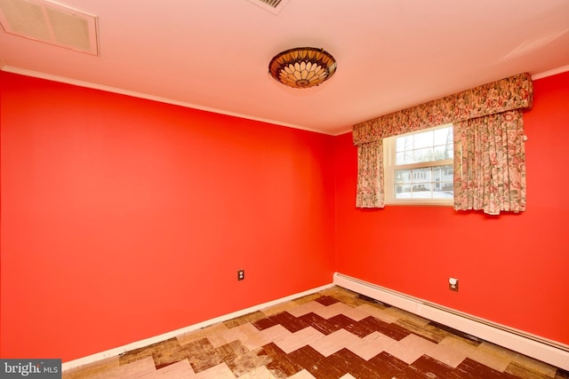 empty room featuring crown molding and a baseboard heating unit