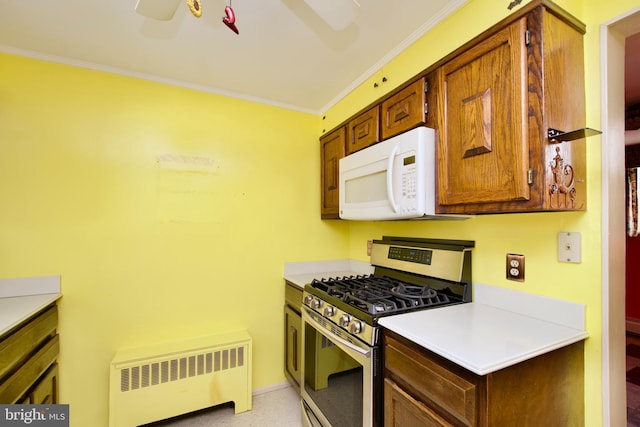 kitchen with radiator, crown molding, stainless steel range with gas stovetop, and ceiling fan