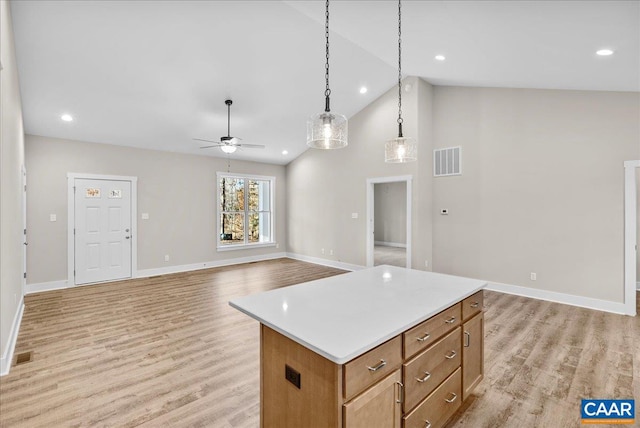 kitchen with ceiling fan, decorative light fixtures, high vaulted ceiling, a kitchen island, and light hardwood / wood-style flooring