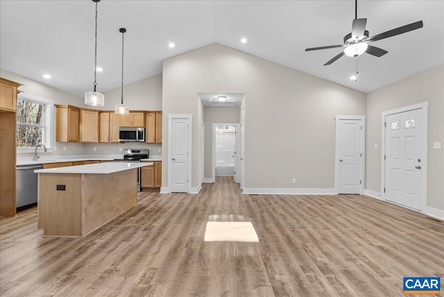 kitchen with ceiling fan, stainless steel appliances, high vaulted ceiling, a kitchen island, and light hardwood / wood-style flooring