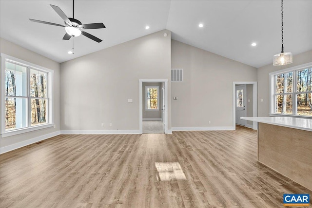 unfurnished living room with ceiling fan, high vaulted ceiling, and light hardwood / wood-style floors