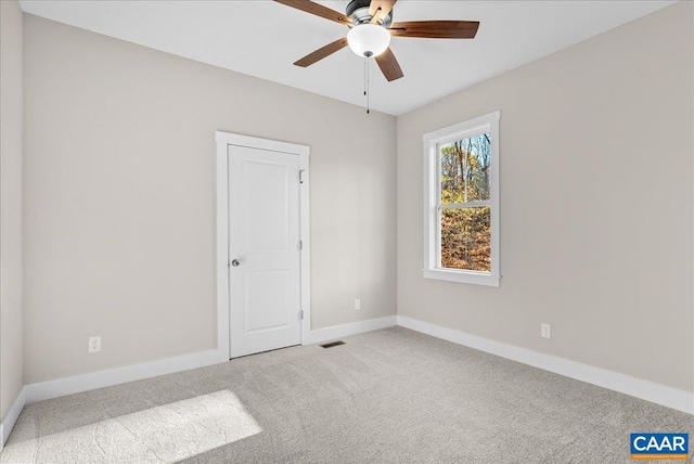 spare room with ceiling fan and carpet