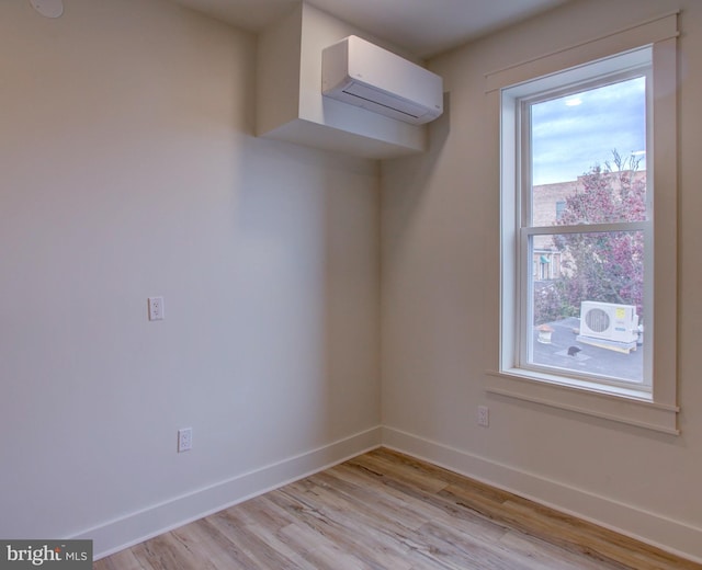 spare room featuring light hardwood / wood-style floors and a wall unit AC