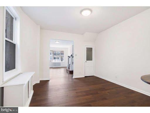 empty room with dark hardwood / wood-style floors