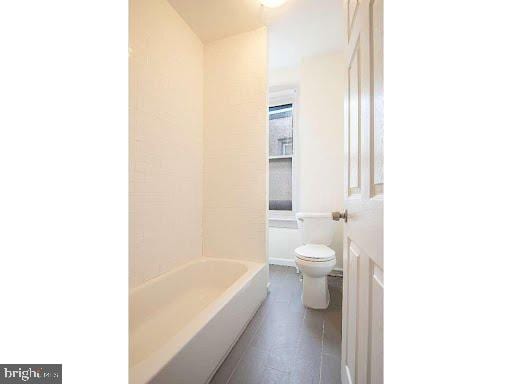 bathroom with toilet and a bathing tub