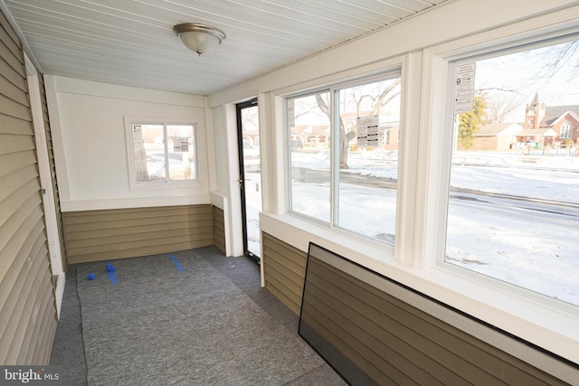 unfurnished sunroom featuring radiator heating unit and wooden ceiling