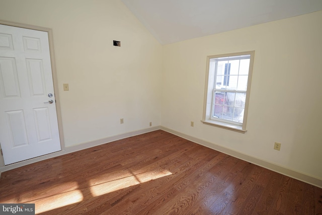 unfurnished room featuring vaulted ceiling and hardwood / wood-style flooring