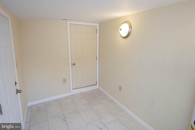 unfurnished room featuring baseboards, visible vents, and marble finish floor