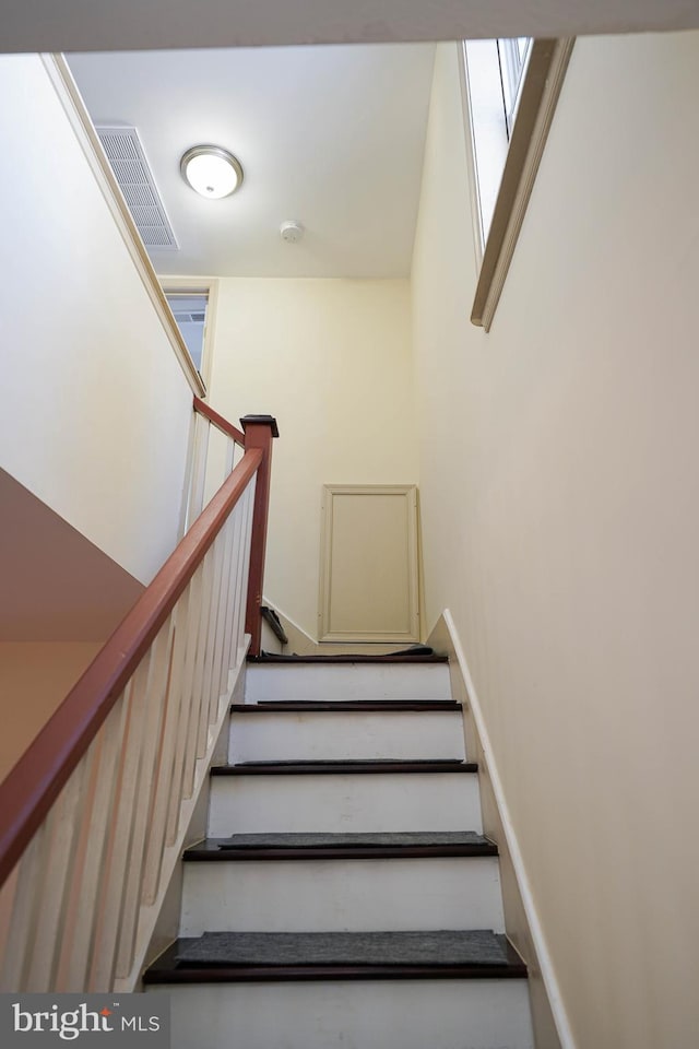 staircase featuring visible vents and baseboards