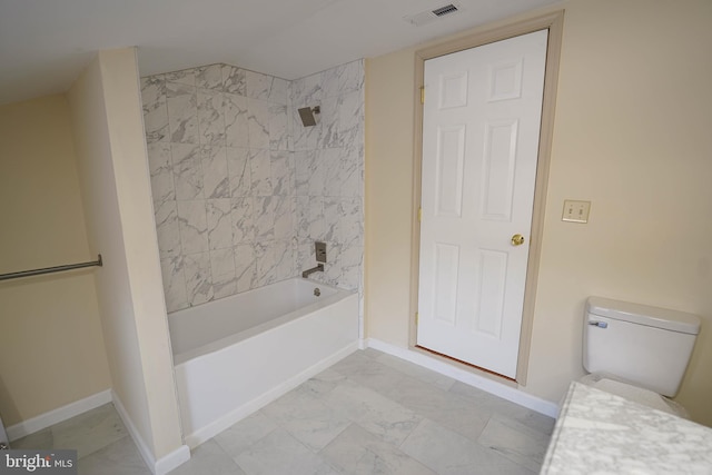 bathroom with tiled shower / bath combo and toilet