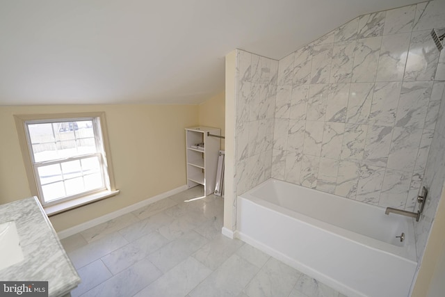 bathroom featuring vanity, baseboards, lofted ceiling, shower / bathing tub combination, and marble finish floor