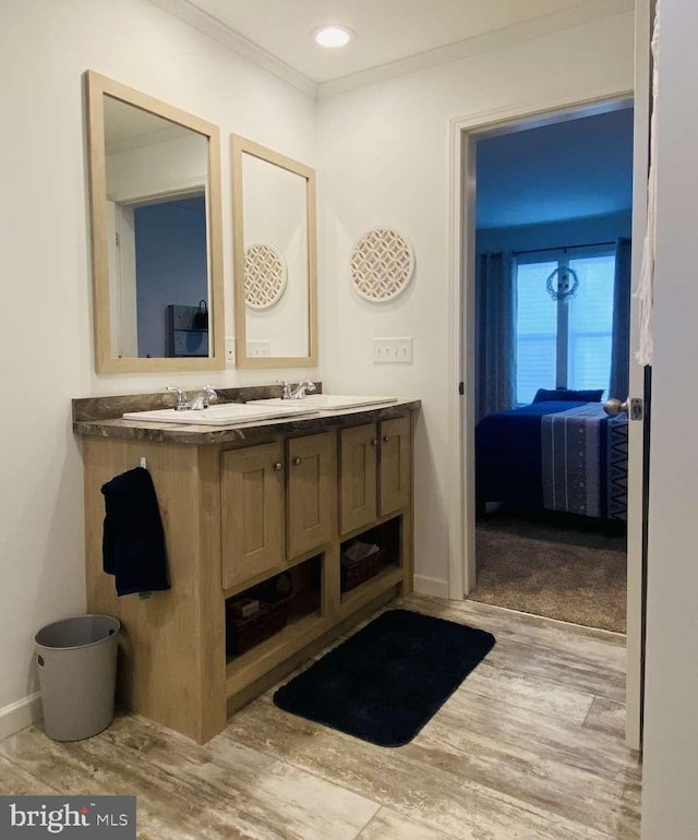 bathroom featuring vanity, wood-type flooring, and ornamental molding