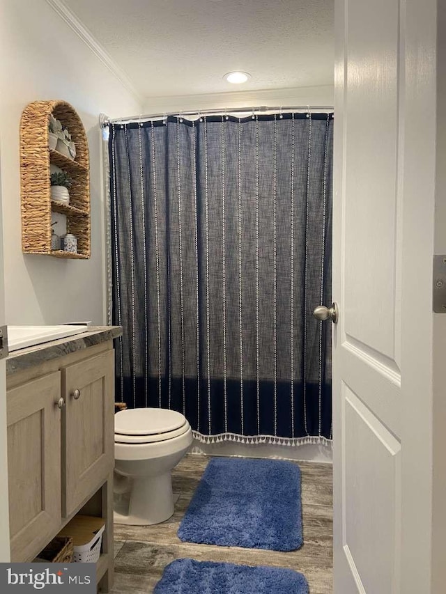 full bathroom with toilet, vanity, hardwood / wood-style floors, shower / bath combination with curtain, and ornamental molding