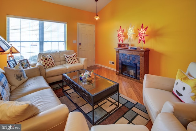 living room featuring wood-type flooring and vaulted ceiling