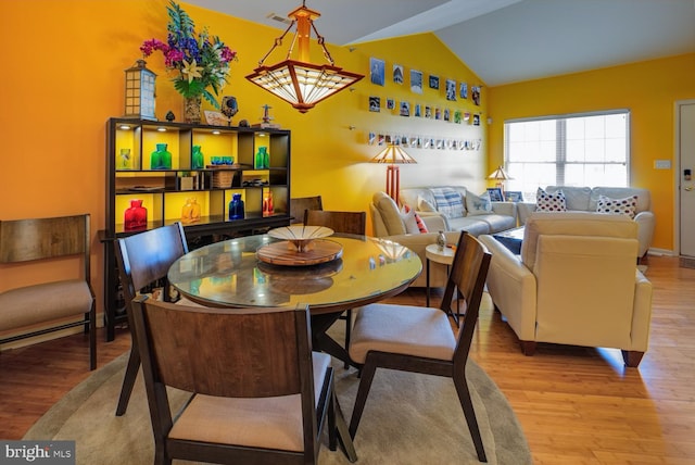 dining area featuring light hardwood / wood-style flooring and vaulted ceiling