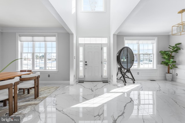 entryway with a wealth of natural light and crown molding