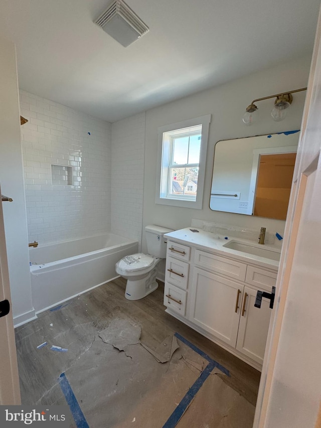 full bathroom featuring vanity, hardwood / wood-style floors, toilet, and tiled shower / bath